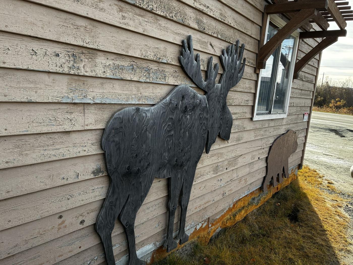 Wooden moose and bear on the side of the shop